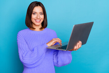 Portrait of attractive cheerful skilled girl using laptop creating project isolated over bright...