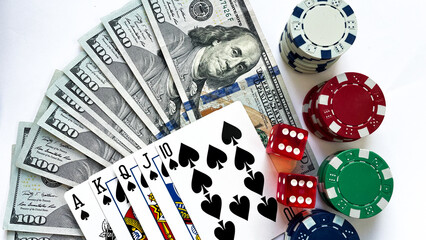 Fototapeta na wymiar A poker setup featuring a royal flush in spades, stacks of red, green, blue poker chips, red dice, and a fan of US dollar bills, ideal for casino promotions, gambling advertisements, or game night vis