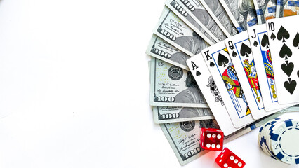 Fototapeta na wymiar A poker setup featuring a royal flush in spades, stacks of red, green, blue poker chips, red dice, and a fan of US dollar bills, ideal for casino promotions, gambling advertisements, or game night vis