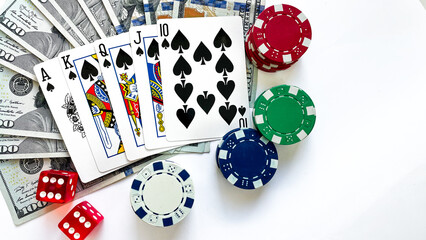 Fototapeta na wymiar Poker chips, playing cards showing a royal flush in spades, red dice, and US dollar bills placed on a white background, representing gambling, luxury, and high-stakes poker. Ideal for casino advertise