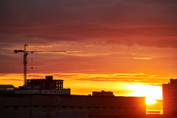 Golden Sunset with Crane and Building Silhouettes