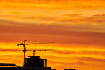 Golden Sunset with Crane and Building Silhouettes