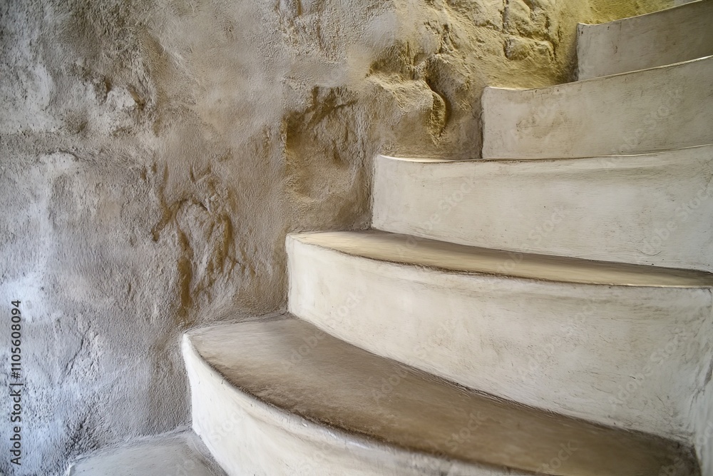Poster A rustic spiral staircase with a textured finish and natural tones. The aged surface adds a sense of history and warmth to the design, creating a charming ambiance.