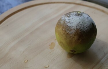 Una toma de cerca de un limón verde con moho, en mal estado 