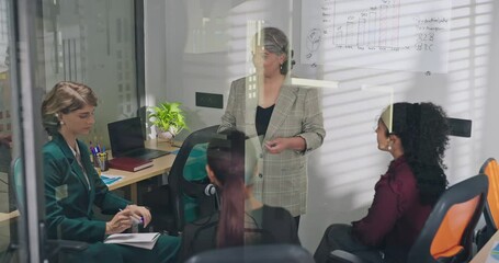 Indian young adult female old elder older boss lady team leader show growth chart white board learn graph data work place teen girl intern expert group talk share stock trade speak idea job office day - Powered by Adobe