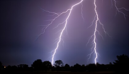 Dramatic lightning strikes against dark cloudy sky. Powerful electric bolts illuminate night sky. Trees in silhouette against storm. Nature powerful energy display. Stormy weather condition. Powerful