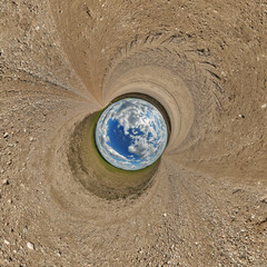 blue hole sphere or globe little planet inside green dry grass or stone with sand frame background