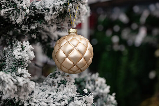 Colorful decorative Christmas ornaments in a box filled with pink shades.