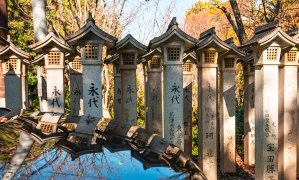 Row of Zen stone lanterns reflecting in water, Yoshino, Honshu, Japan