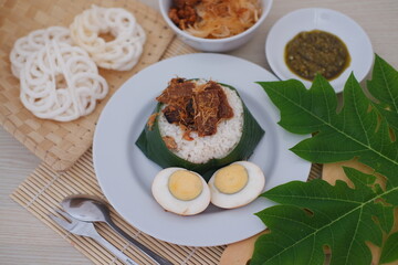 rice with meat, egg, crackers, sambal and noodles on a white background
