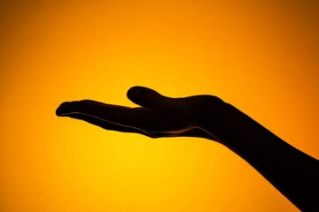 A beautifully poised hand silhouette held against a vibrant orange background, offering a striking visual representation of grace, elegance, and mystery in art.