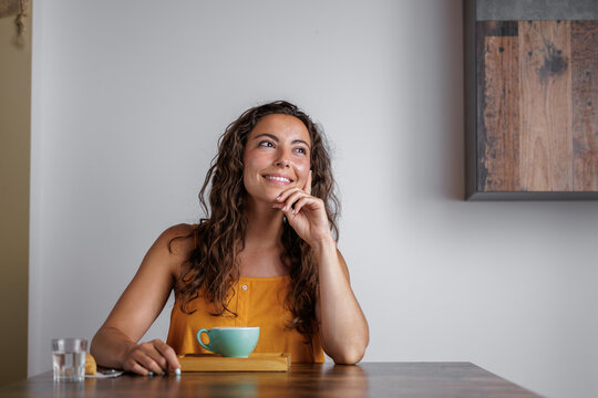 Smiling young woman enjoys her special coffee with latte art. Just by the aroma of the coffee you already know how delicious it is, you will have a lot of energy with the caffeine.