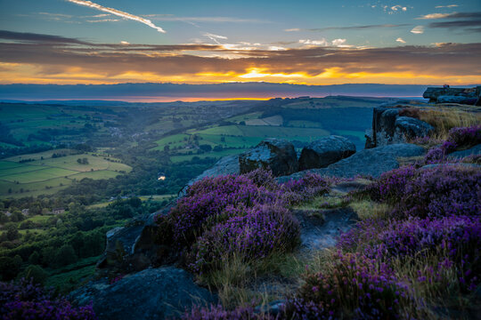 View of landscape from Curbar Edge with purple flowering heather at sunset, Peak District National Park, Baslow, Derbyshire, England, United Kingdom