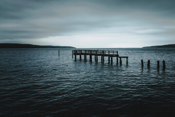 Obraz premium Ruined Serenity The Remains of a Pier on a Tranquil Lake