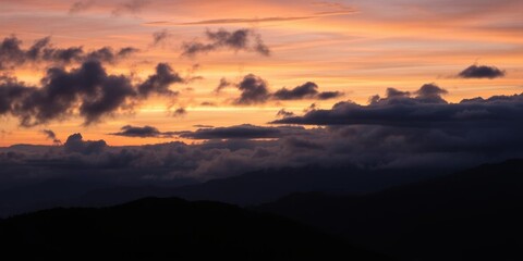 Obraz premium A breathtaking view of a mountain valley at twilight, where the last rays of the setting sun meet the emerging darkness of night, clouds, environment, valley
