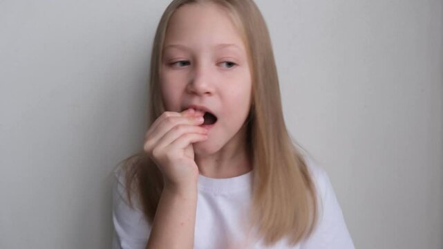 A dental plate for children of rainbow color. The child holds orthodontic braces in his hands to align the teeth and expand the jaw.	