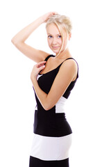 Fototapeta premium Fashion portrait of a young beautiful blonde in a black dress with open shoulders