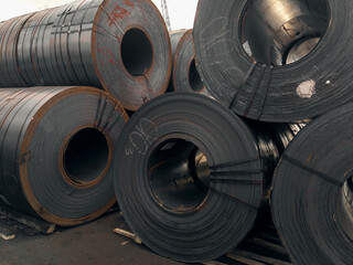 Steel rolls. A roll of sheet iron. Hot rolled steel rolls are stored outdoors. Sheet metal in the port. Steel rolls are available in stock. Rolls of steel sheet.