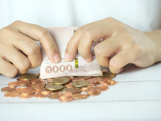 Hand holding money and counting money on desk. Financial business concept. Copy space.