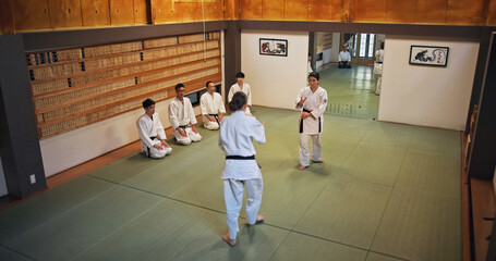 Martial arts, demonstration and Japanese people with learning, exercise and karate etiquette in dojo. Japan, training and fight studio with sport, discipline and warrior in taekwondo class in gym