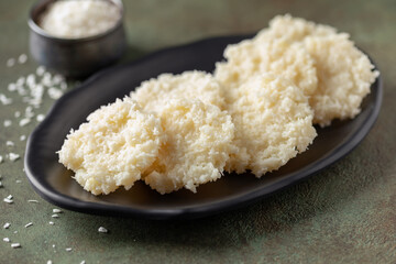 Cocada, traditional latin american coconut candy with grated coconut in plate.