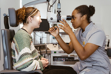 Female Ophthalmologist examining patient's eye in clinic at hospital