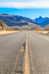 A long, empty road with a mountain in the background