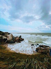 Scenic coastal view with crashing waves and rocky shore.