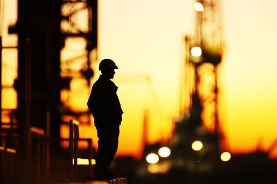 Silhouette of a driller against the backdrop of a drilling rig