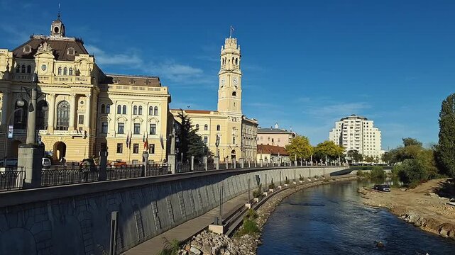 The architecture of Oradea City Hall, located on the riverbank, illuminated by the morning sun.