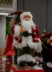 Christmas figurine of Santa Claus in red and green suit with gift bag