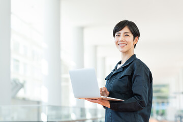 オフィスビルでパソコンを使う作業員の女性