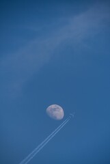 Airplane and Moon in Daytime Sky