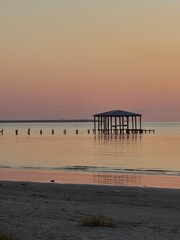 Sunrise with a sunken pier lonely across the water