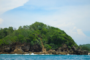 Naklejka premium Long sea view with white cliff island with trees in the distance seen from the sea.