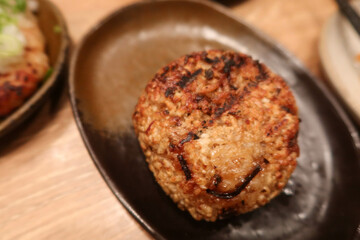 close up of grilled roasted rice ball or can be called onigiri on a black plate with copy space