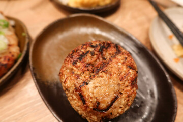 close up of grilled roasted rice ball or can be called onigiri on a black plate with copy space