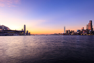 Obraz premium Vibrant Sunset Over Hong Kong's Iconic Skyline and Victoria Harbour