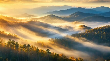 Fototapeta premium Low sunlight breaking through fog over a mountain ridge, casting golden light across misty peaks and valleys