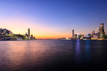 Naklejka premium Vibrant Sunset Over Hong Kong's Iconic Skyline and Victoria Harbour