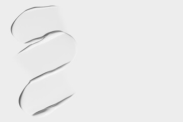 Smears of white cosmetic cream on a light background