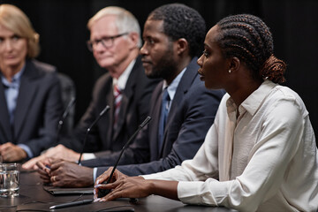 Side view of high profile African American female politician reporting on reform plans during press...