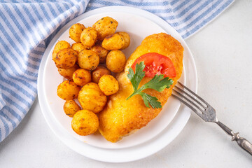 Breaded chicken cutlet with whole fried baby potato side