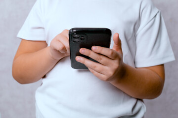 A teenager using a mobile phone on a light background. A concept of modern technology and communication.