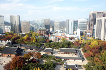 Fototapeta premium Autumn scenery of Deoksugung Palace, the palace of the Joseon Dynasty, surrounded by large buildings in the heart of Seoul, Korea