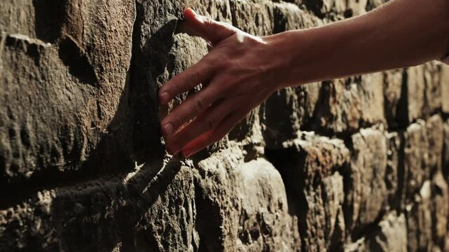 Touching old castle wall, Happy tourist man in Barcelona, Spain. Vacation exploring interesting places to travel, student vacation, young man portrait walking in gothic square, old european city. 