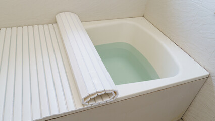 お風呂に溜めたお湯と保温用のフタ