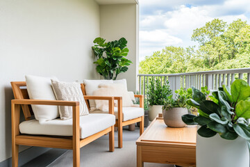 Fototapeta premium Cozy balcony with modern wooden furniture, potted plants, and bright sky, perfect for relaxation and outdoor living.