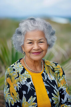 Elderly Maori woman smiles warmly in floral cardigan outdoors