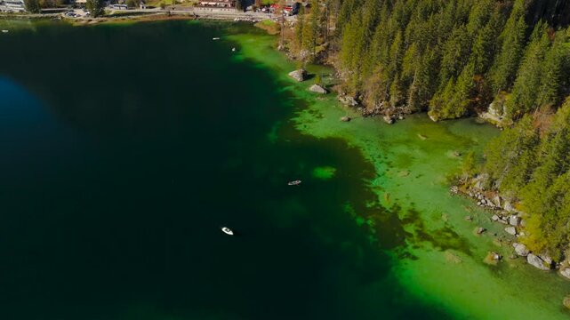 Hintersee in Ramsau, Germany, captured from above in autumn, reveals turquoise waters, the Ramsauer Ache, majestic Alps, and the enchanting Magic Forest. Enjoy boat rentals on this serene lake. 